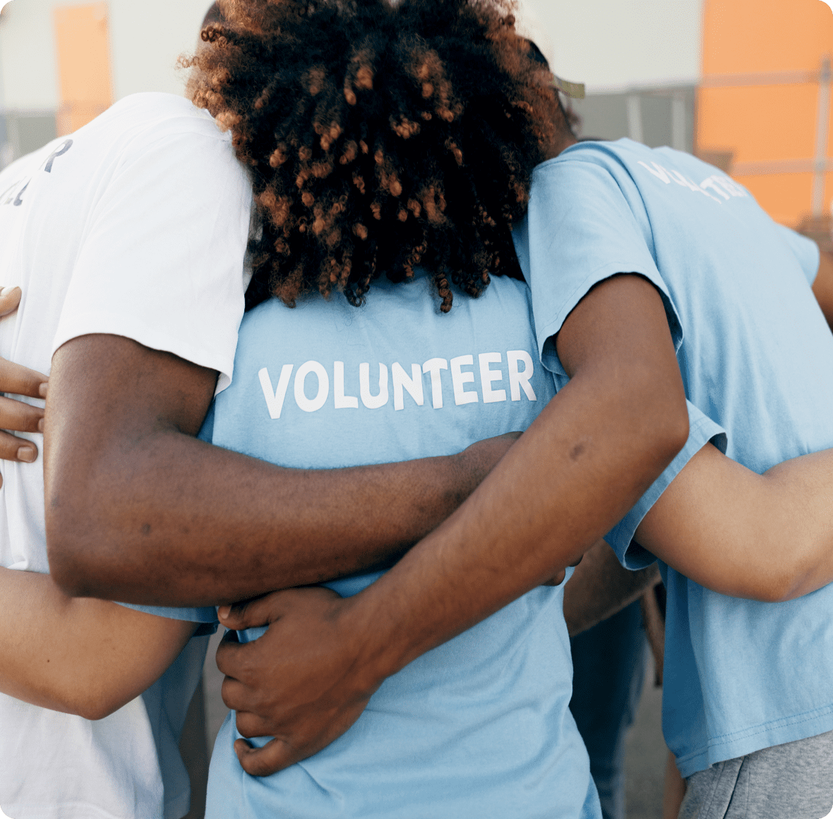 Team of volunteers hugging tightly