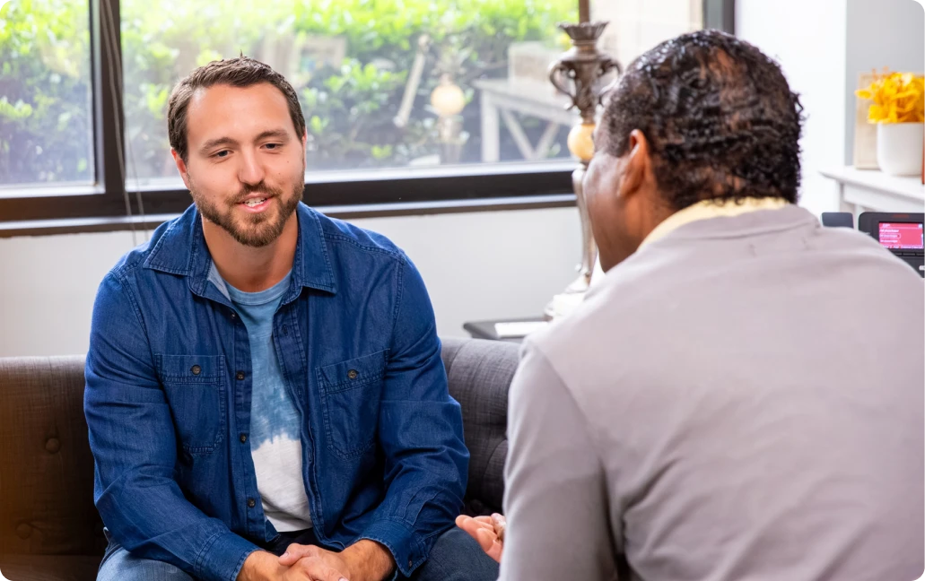 Two people having a conversation indoors.